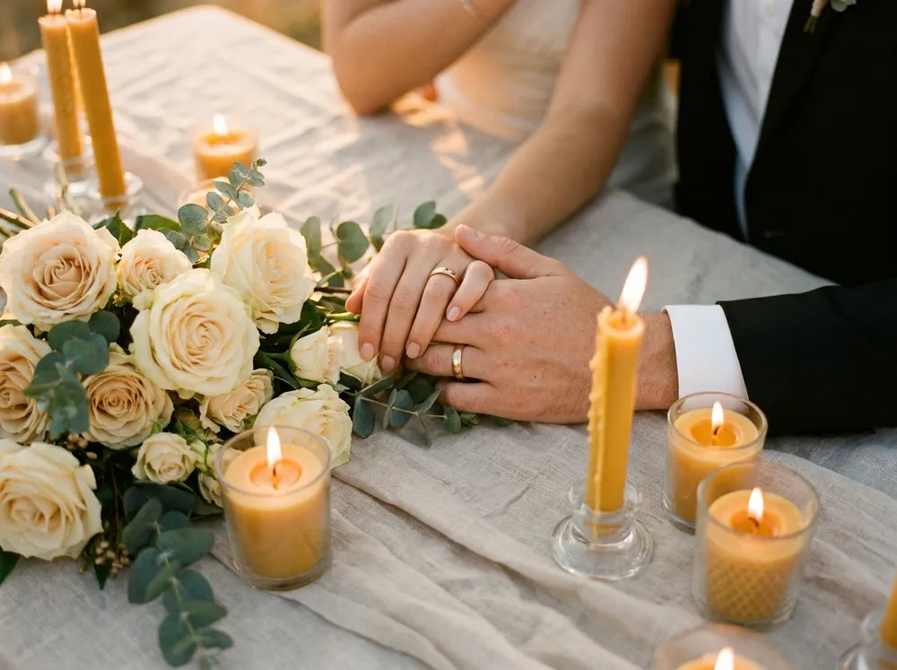 Hochzeit — Ringe und Brautstrauß bei Kerzenlicht